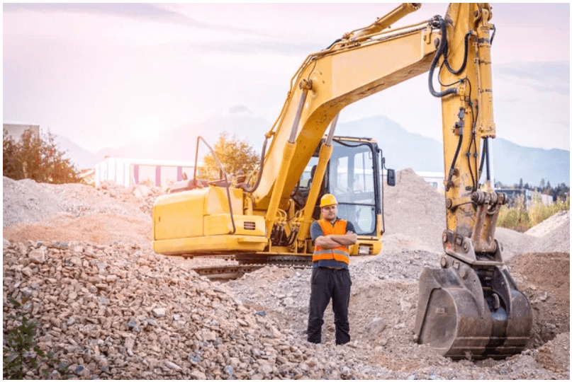 Construction worker with excavator at site.