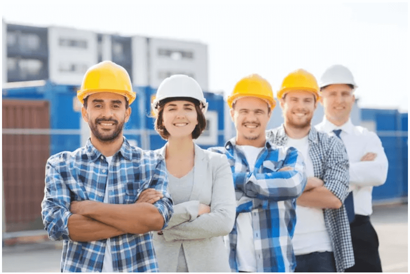 Group of construction workers smiling outdoors.